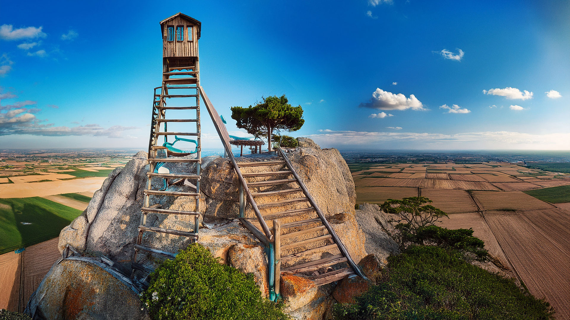 Symbolbild für absurde Bauwerke – Zwei unlogisch platzierte Holzleitern führen auf einen Felsen mit Häuschen, ohne funktionalen Zugang.